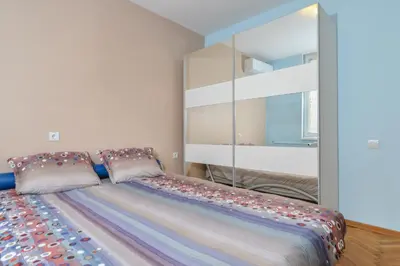 a bedroom with a large bed with a large mirror at Comfortable One Bedroom Apartment in a Lively Area | Zona B5 | Russian Square in Sofia