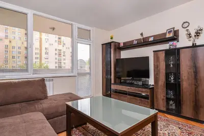 a living room with a couch and a flat screen tv at Comfortable One Bedroom Apartment in a Lively Area | Zona B5 | Russian Square in Sofia