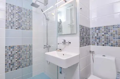 a white bathroom with a sink and a shower at Comfortable One Bedroom Apartment in a Lively Area | Zona B5 | Russian Square in Sofia