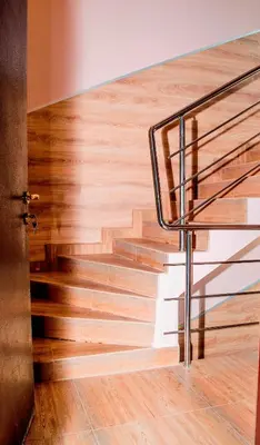 a wooden staircase with a metal handrail and wooden floor at Комплекс Кремен in Blagoevgrad