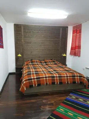 a bedroom with a bed with a wooden headboard at Holiday Village Kochorite in Pamporovo