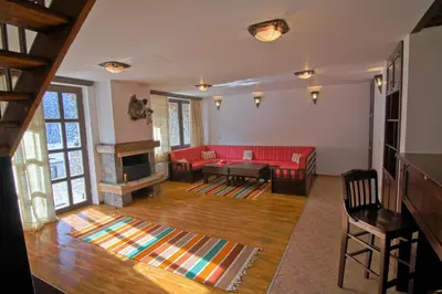 a living room with a red couch and a table at Holiday Village Kochorite in Pamporovo