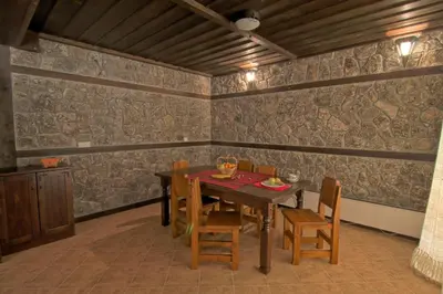a dining room with a wooden table and chairs at Holiday Village Kochorite in Pamporovo