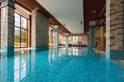 a swimming pool with blue water in a building at Terra Hotel in Bansko