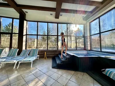 a woman standing on the edge of a swimming pool at Terra Hotel in Bansko