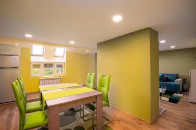 a dining room with a table and green chairs at Serdika Round Tower Apartments in Sofia