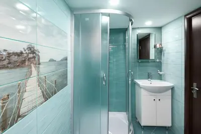 a bathroom with a sink and a glass shower at Serdika Round Tower Apartments in Sofia