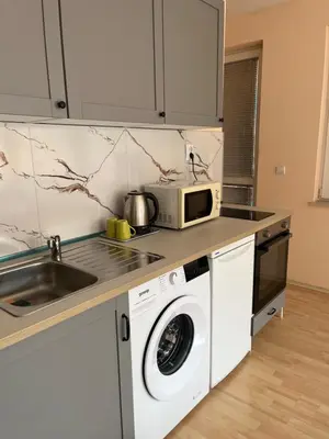 a kitchen with a washing machine and a microwave at BLOCK 531 ApartHouse BLOCK 533 in Sofia