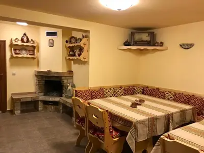 a dining room with a table and a fireplace at Vila Rila Samokov in Samokov