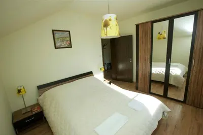 a bedroom with a white bed and a large mirror at Vila Rila Samokov in Samokov