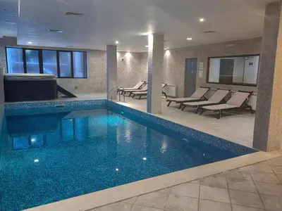a swimming pool in a hotel with chairs and tables at Chamkoria Chalets in Borovets
