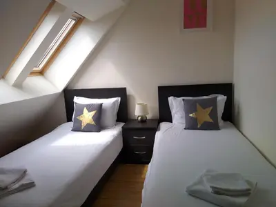 two twin beds in a attic bedroom with a window at Chamkoria Chalets in Borovets
