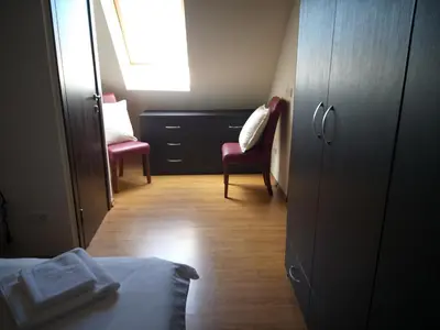 a bedroom with a bed and two chairs and a window at Chamkoria Chalets in Borovets