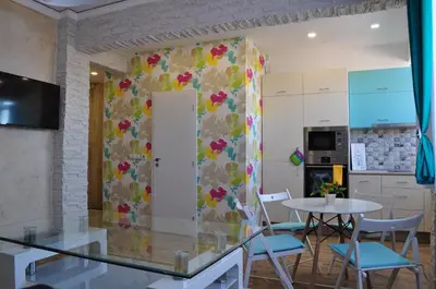 a room with a table and chairs and a wall at Sofia Central Pretty Apartment in Sofia