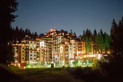 a large building is lit up at night at Complex Kamelia in Pamporovo