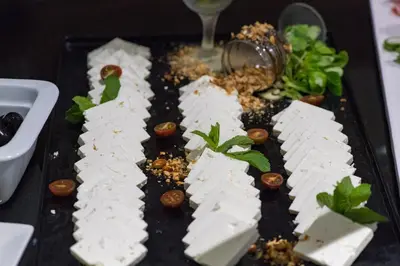a plate of food with cheese and vegetables on a table at Complex Kamelia in Pamporovo