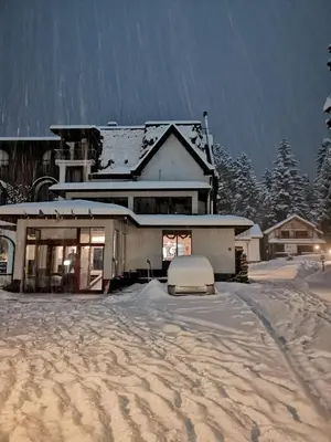 a house with snow on the ground in front of it at Saint George Borovets Hotel in Borovets