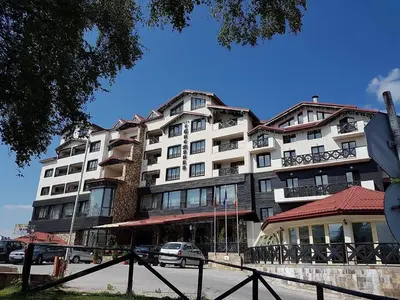 a large building with cars parked in front of it at Snezhanka Apartments TMF in Pamporovo