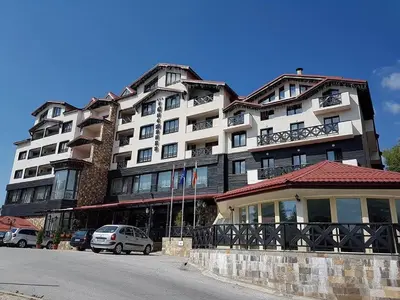 a large building with cars parked in front of it at Snezhanka Apartments TMF in Pamporovo