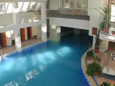 a large blue swimming pool in a building at Snezhanka Apartments TMF in Pamporovo