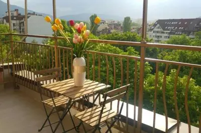 a table with a vase of flowers on a balcony at Center apartment with amazing view in Sofia