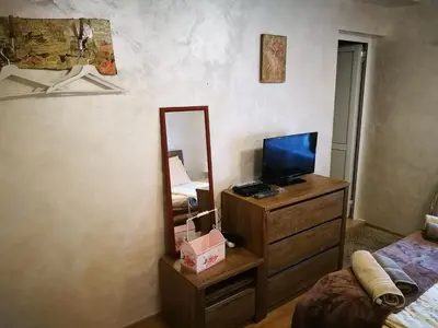 a bedroom with a mirror and a dresser with a television at Hotel Paradise in Sofia