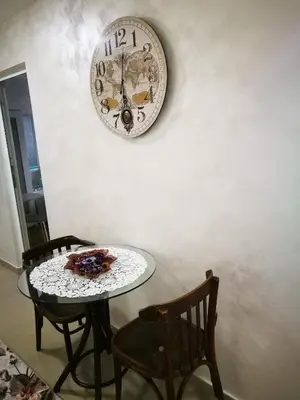 a table and two chairs and a clock on a wall at Hotel Paradise in Sofia