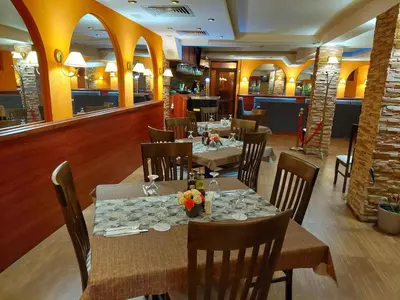 a dining room with tables and chairs in a restaurant at Eleganza Family Hotel - Free Parking in Sofia
