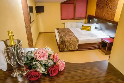 a hotel room with a bed and a table with flowers at Eleganza Family Hotel - Free Parking in Sofia