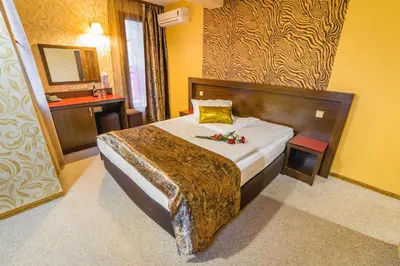 a hotel room with a bed with flowers on it at Eleganza Family Hotel - Free Parking in Sofia