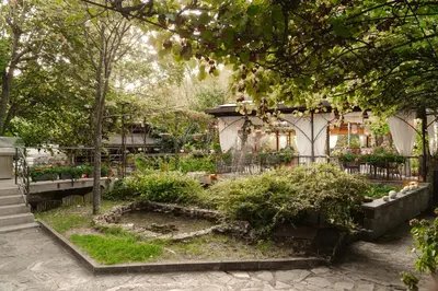 a garden in front of a building with flowers at Family Hotel Edia-Sandanski in Sandanski