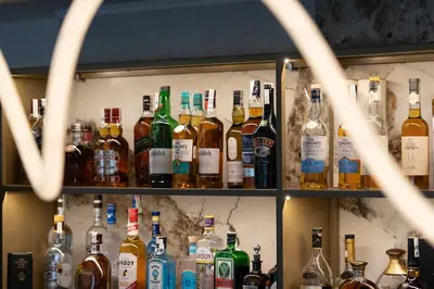 a shelf filled with lots of bottles of alcohol at Family Hotel Edia-Sandanski in Sandanski