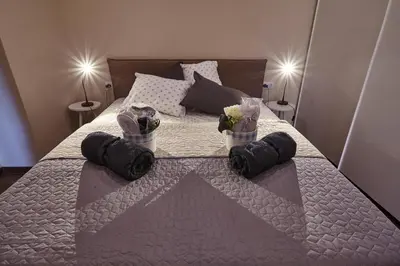 a bedroom with a bed with towels and flowers on it at City Center Studio in Plovdiv