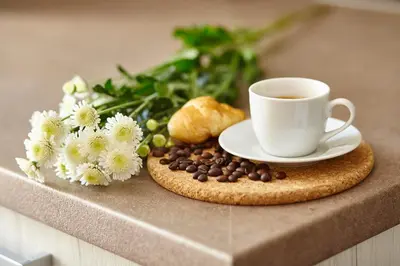 a cup of coffee and flowers on a table at City Center Studio in Plovdiv