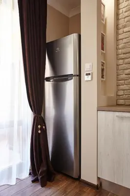 a stainless steel refrigerator in a kitchen next to a window at City Center Studio in Plovdiv