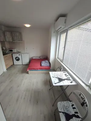 a small room with a red bed and a table at Sun Стамат Икономов 11 in Plovdiv