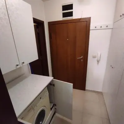 a small kitchen with a washing machine and a wooden door at spa in Plovdiv