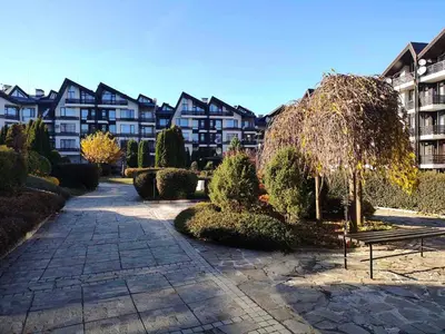 a park with a bench in front of a building at Aspen Golf and Ski Resort in Bansko
