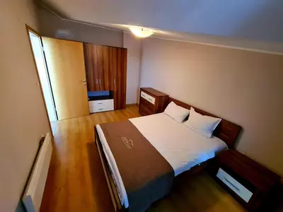 a bedroom with a bed with white sheets and a window at Aspen Golf and Ski Resort in Bansko