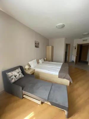 a bedroom with a large bed and a couch at Aspen Golf and Ski Resort in Bansko