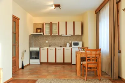 a kitchen with a table and chairs in a room at Guest House Dzhangal in Bansko