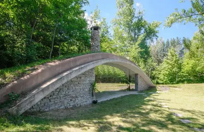 a stone bridge over a river in a park at Omaya Eco Village in Gaytaninovo