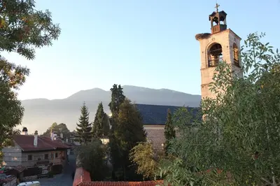 a church with a tower with a clock on it at Dedo Pene Inn in Bansko