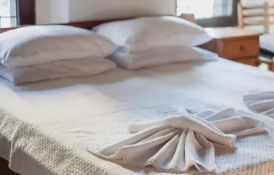 a white bed with white towels on it at Dedo Pene Inn in Bansko