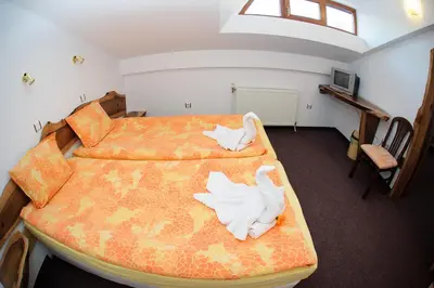 a bedroom with two beds with white towels on them at Family Hotel Nadejda in Bansko
