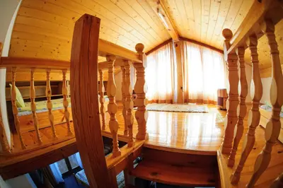 a wooden spiral staircase in a room with a window at Family Hotel Nadejda in Bansko
