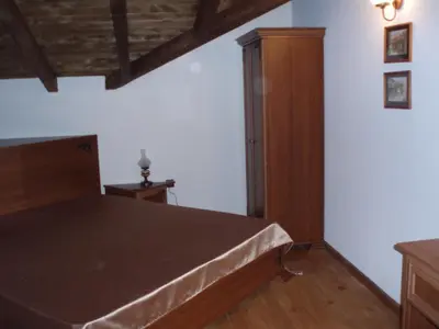 a bedroom with a bed and a wooden cabinet at Guest House Valevicata in Bansko