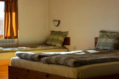 a room with two beds and a couch at Durchova Kashta Family Hotel in Bansko