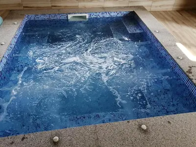 a swimming pool with water in the middle at Къща за гости Мира in Strelcha