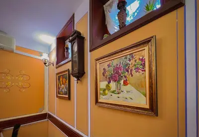 a hallway with a painting of a vase of flowers at Family Hotel at Renaissance Square in Plovdiv